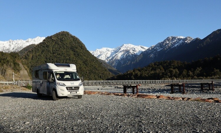 A Wilderness motorhome parked on a gravel road near a national park