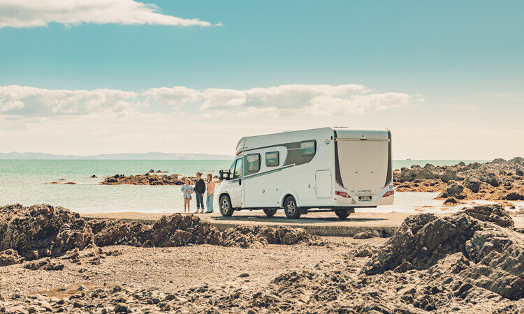 A family making a stop by the beach whie travelling with their Wilderness motorhome