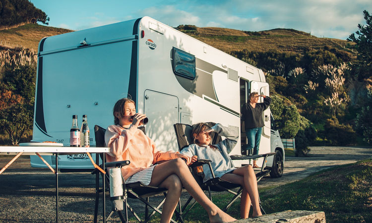 A family relaxing and enjoying a warm evening outside of their motorhome