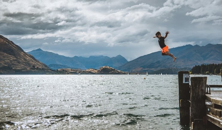 Summer at Lake Wanaka with a boy diving into the lake