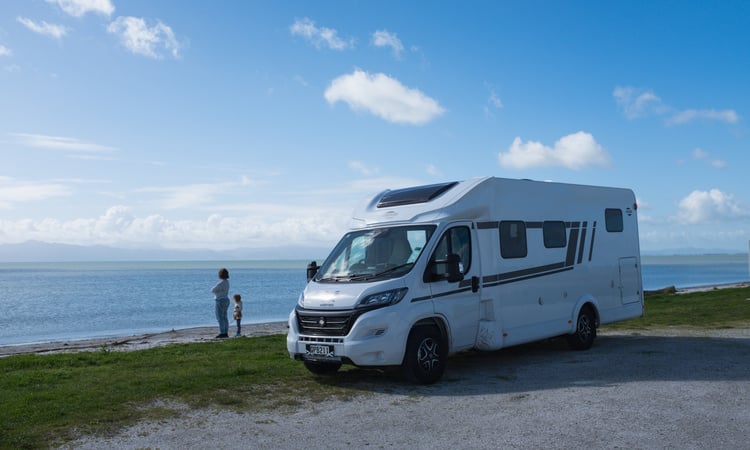 A mother and child looking over a sea view outside of their Wilderness motorhome