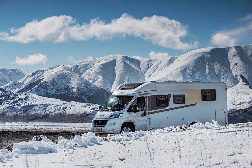 A Wilderness Motorhome being driven in between snowy mountains