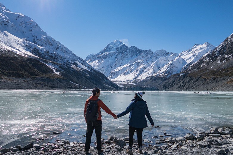 Couple enjoying their outdoor time at the Hooker Valley Track during winter