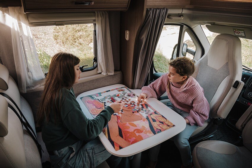 Kids playing a puzzle in their motorhome