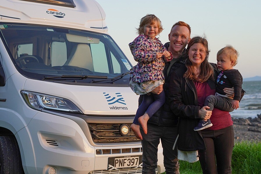 Family posing in front of a Wilderness motorhome