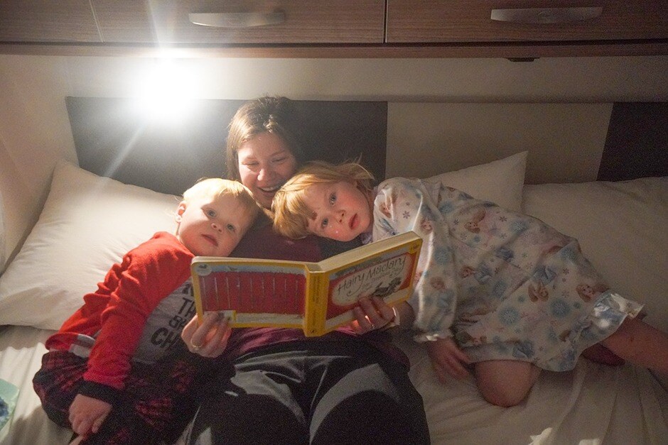 Mom reading bedtime stories to her children in a motorhome
