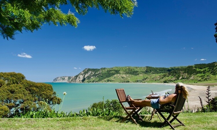 A woman relaxing while looking at a coastal view