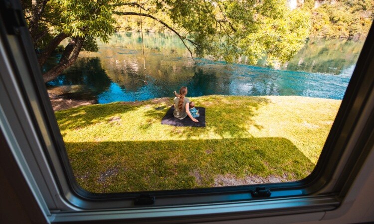 A mom and child enjoying their time by the river outside of their motorhome