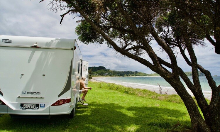 A motorhome with a self-contained sticker on the rear panel