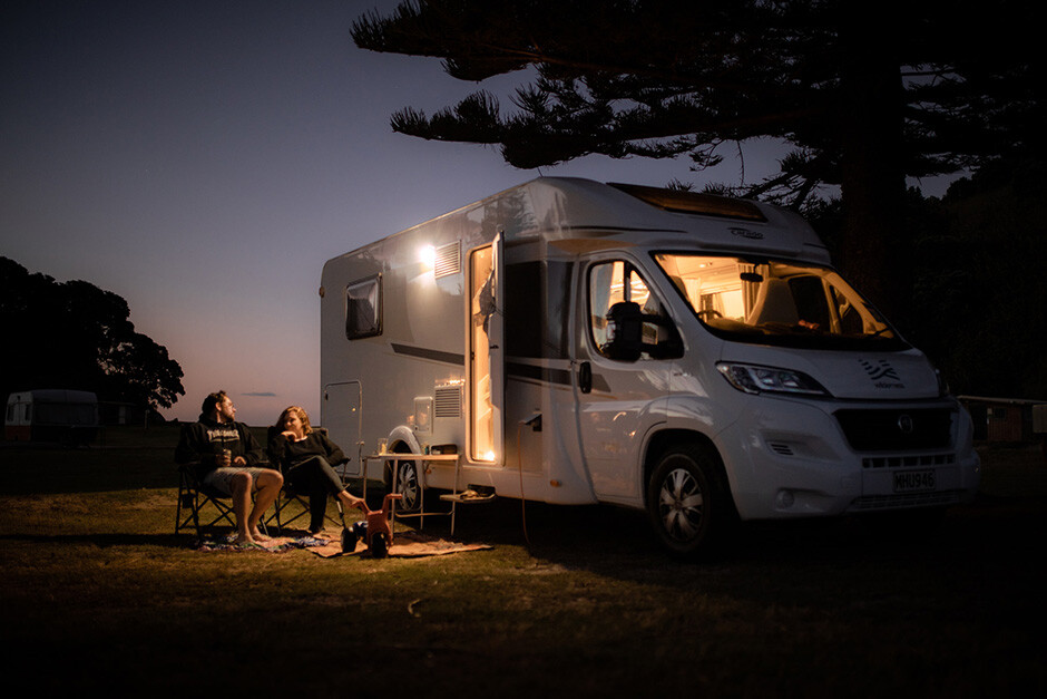 A couple enjoying their evening outside of their Double for 4 motorhome